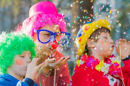 a mother and her children are playing with confetti in carnival costume